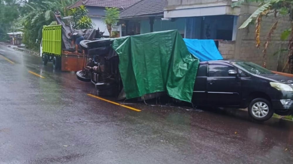 Diduga Hilang Kendali, Truk Terguling di Desa Antiga dan Timpa Mobil dari Arah Berlawanan
